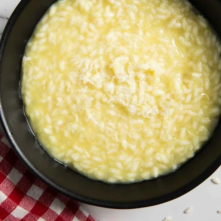 A bowl of creamy classic Italian risotto garnished with herbs and Parmesan cheese