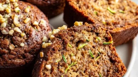 Low carb keto zucchini bread sliced and served with butter on a wooden board