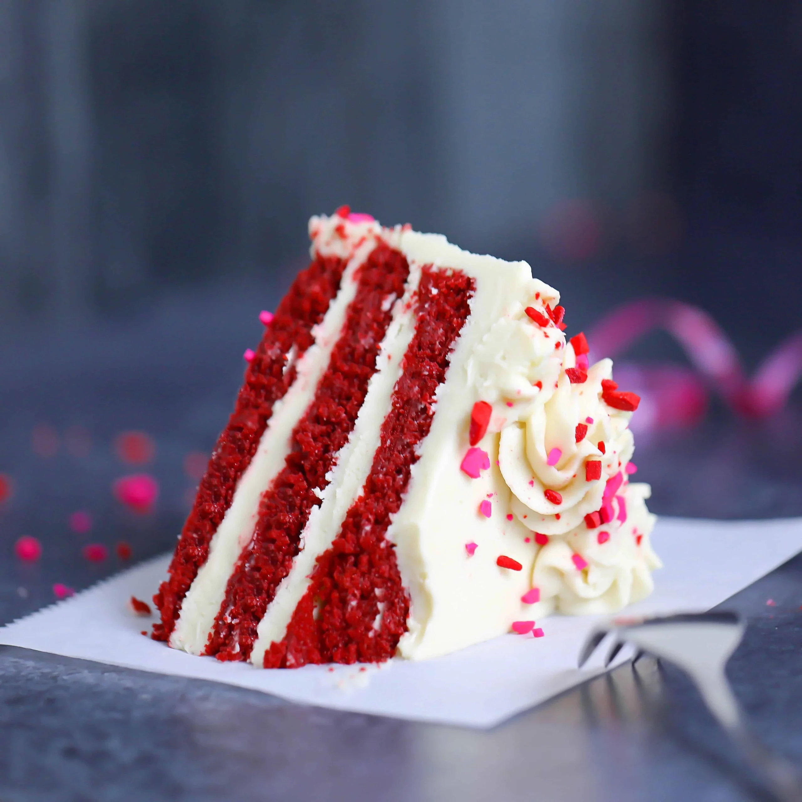 Low-carb red velvet cake and cupcakes displayed on a festive table