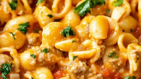 Delicious one pot taco pasta garnished with cheese and fresh herbs