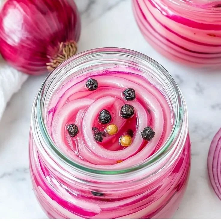 Homemade pickled red onions in a jar, ready to enhance your meals.