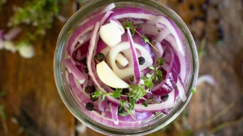 Delicious pickled red onions in a jar, ready to enhance your dishes.