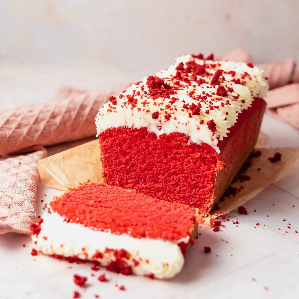 Low carb Red Velvet Cake topped with cream cheese frosting on a white plate.