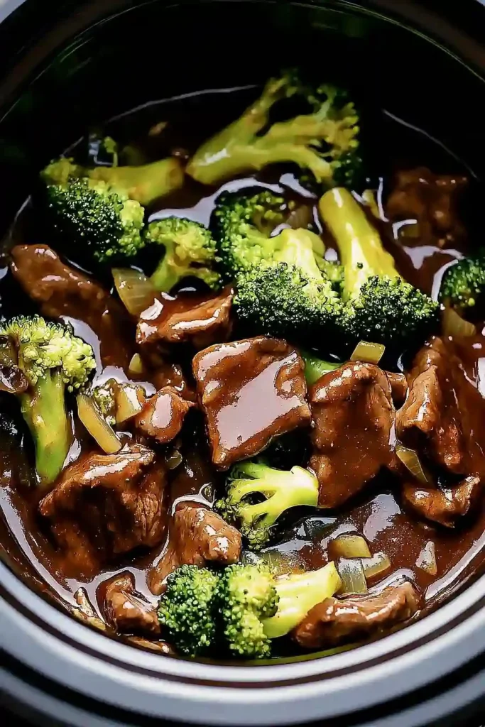 Savory crock pot beef and broccoli dish served with rice on a plate.