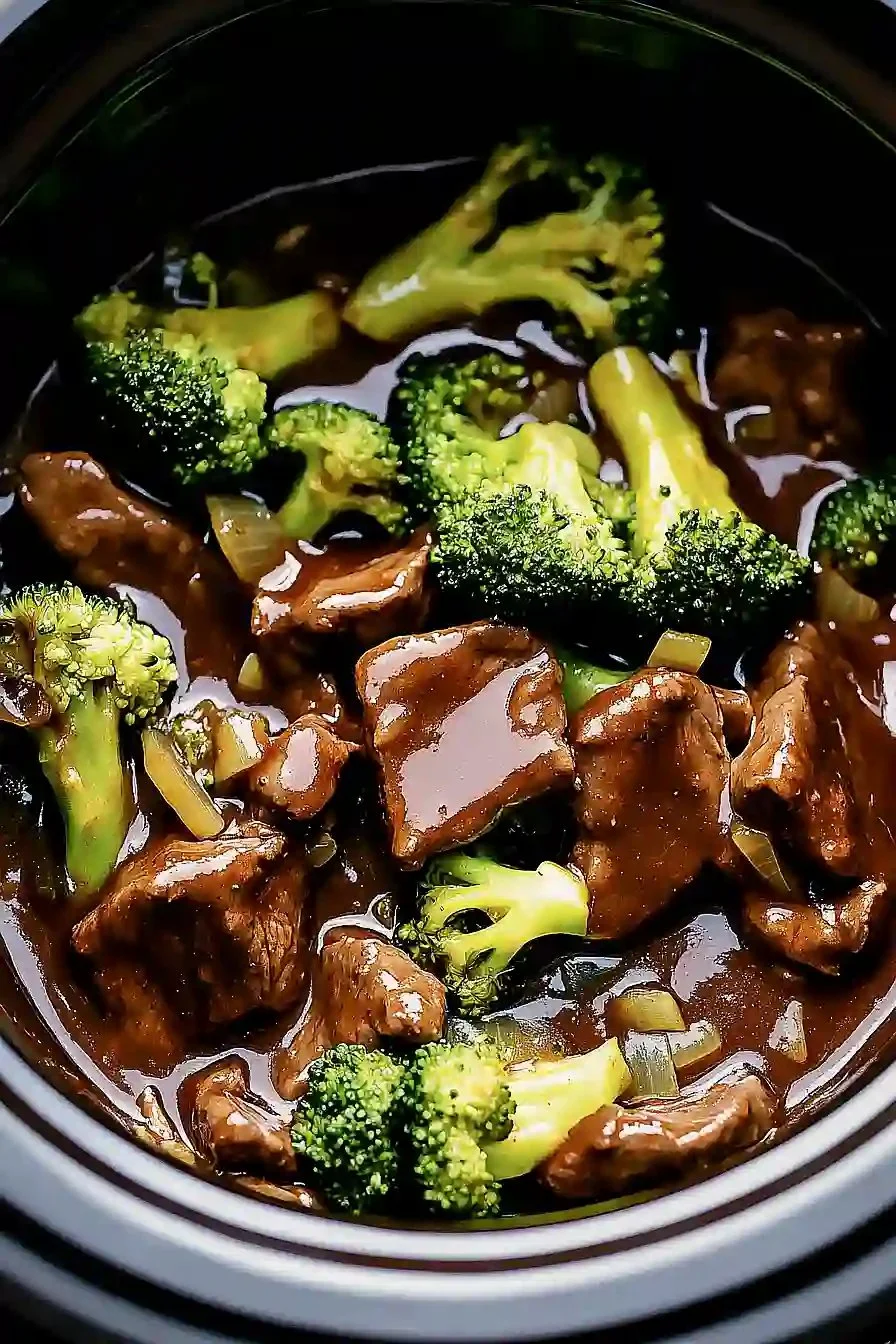Savory crock pot beef and broccoli dish served with rice on a plate.