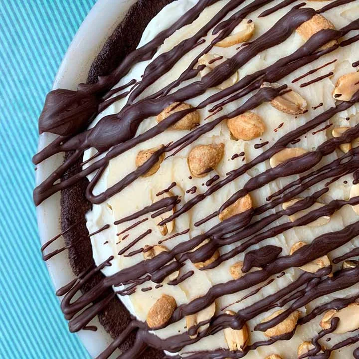 Delicious Sugar-Free Snickers Pie topped with chocolate and peanuts