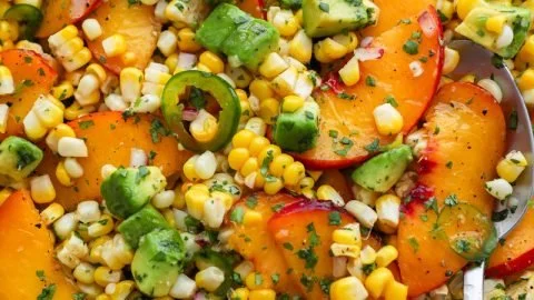 Sweet Corn Salad with Peaches garnished with fresh herbs