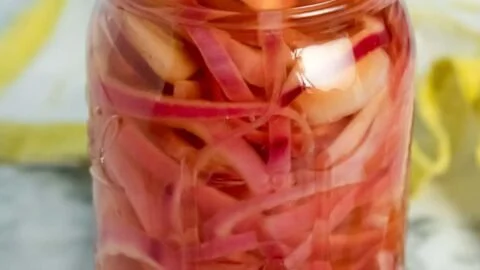 Jar of sweet pickled onions ready for serving with various dishes