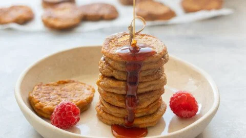 Fluffy sweet potato pancakes topped with maple syrup and fresh berries