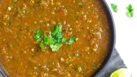 Bowl of fresh homemade salsa with ripe tomatoes, onions, and cilantro.