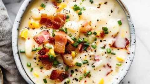 Bowl of creamy sweetcorn chowder topped with fresh herbs