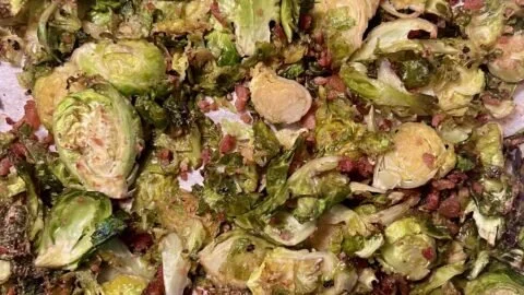 Delicious caramelized Brussels sprouts with bacon on a white plate