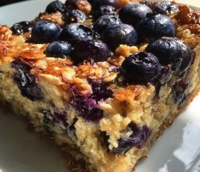 Dish of blueberry baked oatmeal topped with fresh blueberries and nuts.