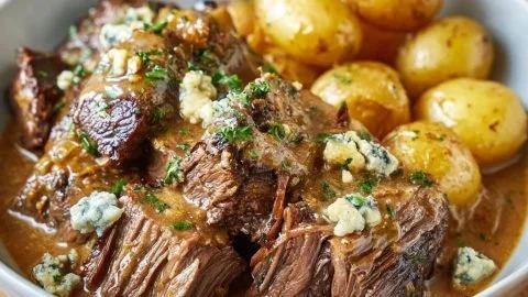 Delicious braised beef with tender potatoes served on a rustic plate.