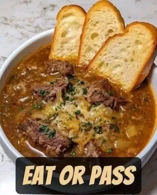 Bowl of delicious French onion beef short rib soup, garnished with herbs.