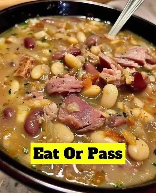 A bowl of hearty Navy Bean and Ham Hock Soup garnished with herbs.
