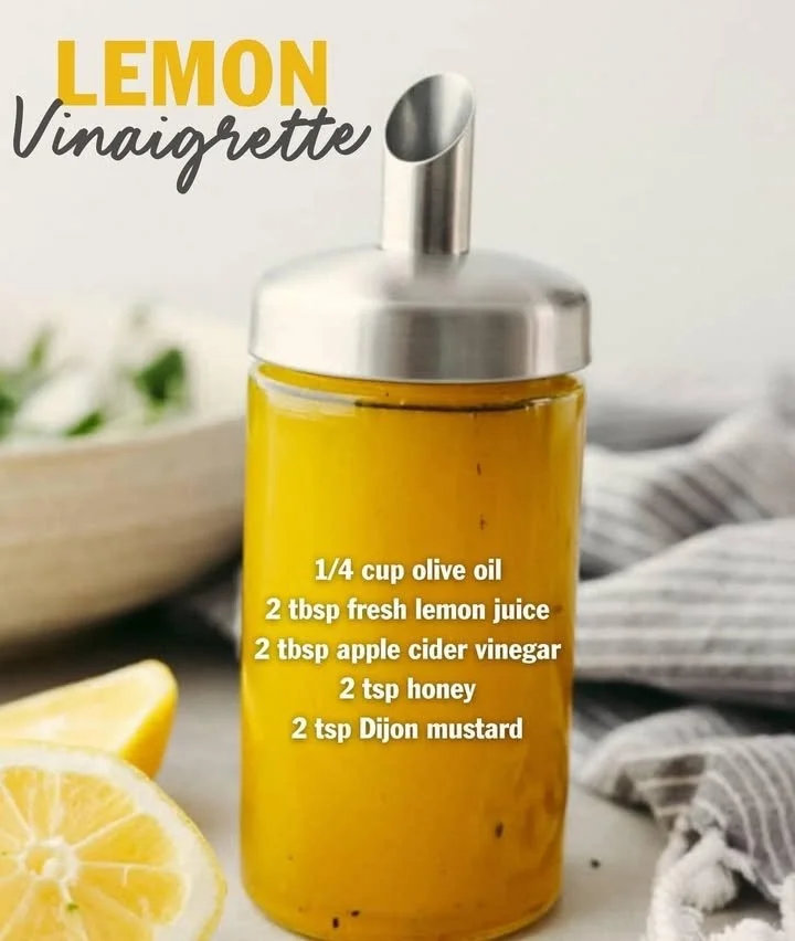 Homemade lemon vinaigrette salad dressing in a glass jar with a fresh salad.