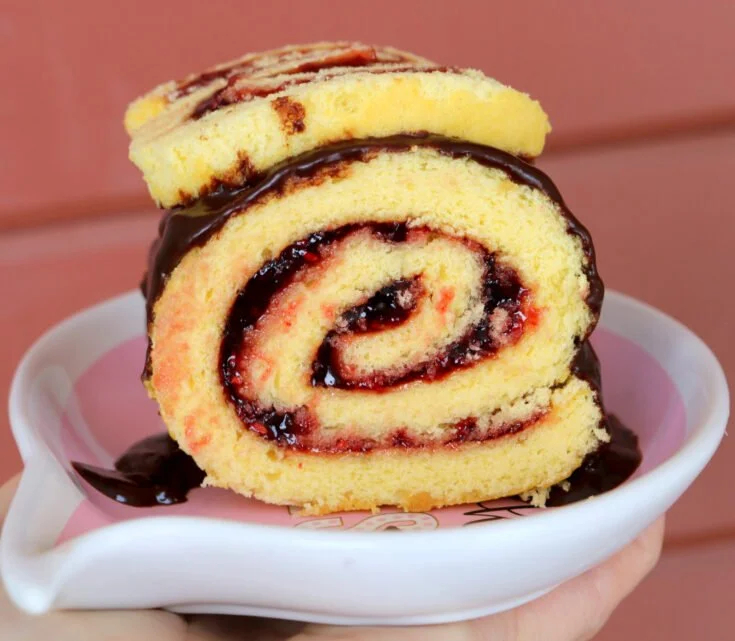 Delicious raspberry roll cake filled with creamy raspberry filling.
