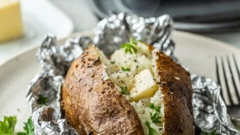 Delicious oven baked potatoes wrapped in foil, ready to be served.
