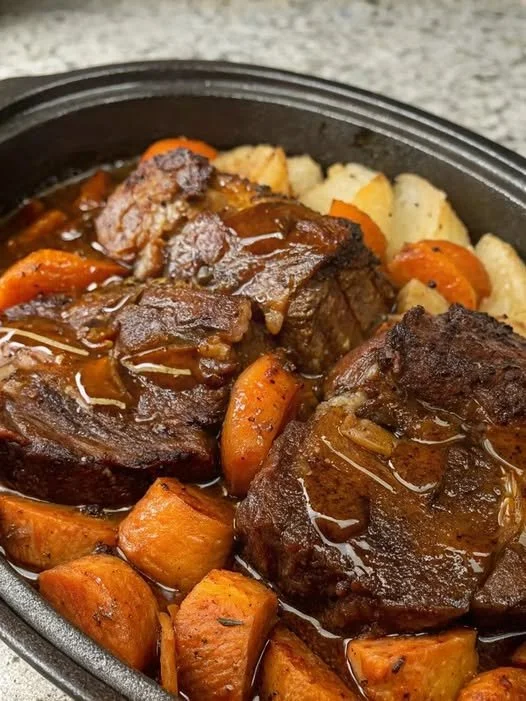 Slow cooker pot roast served with vegetables in a hearty gravy