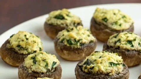 Plate of delicious tofu stuffed mushrooms topped with herbs