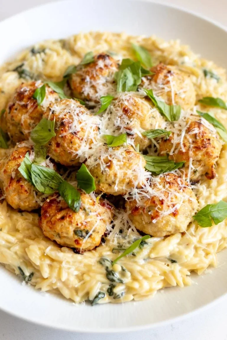 Baked chicken ricotta meatballs with creamy spinach orzo on a plate