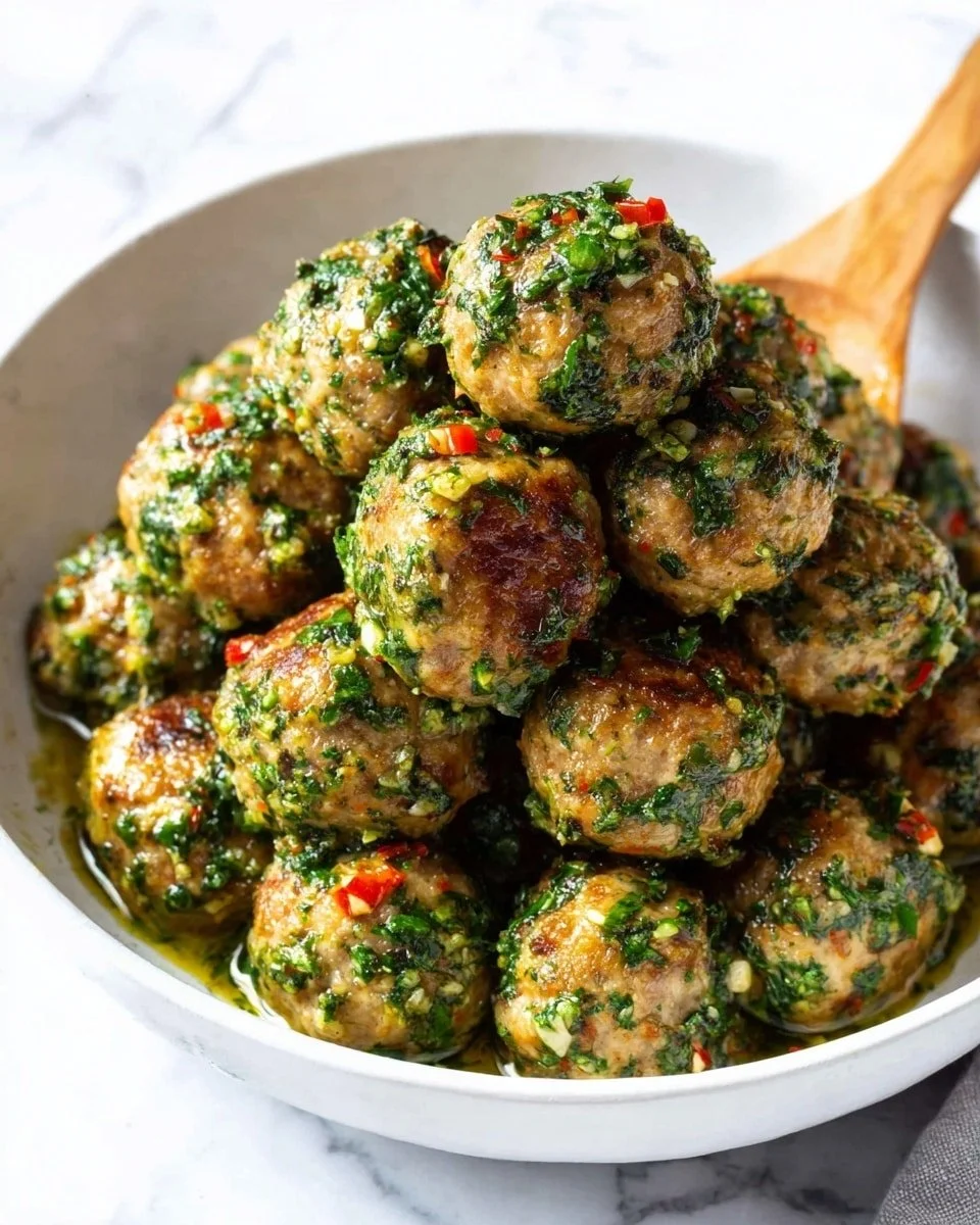 Plate of ground turkey meatballs with fresh herbs and Parmesan cheese