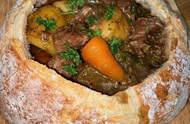 Delicious beef stew served in a warm bread bowl, perfect for cozy meals.