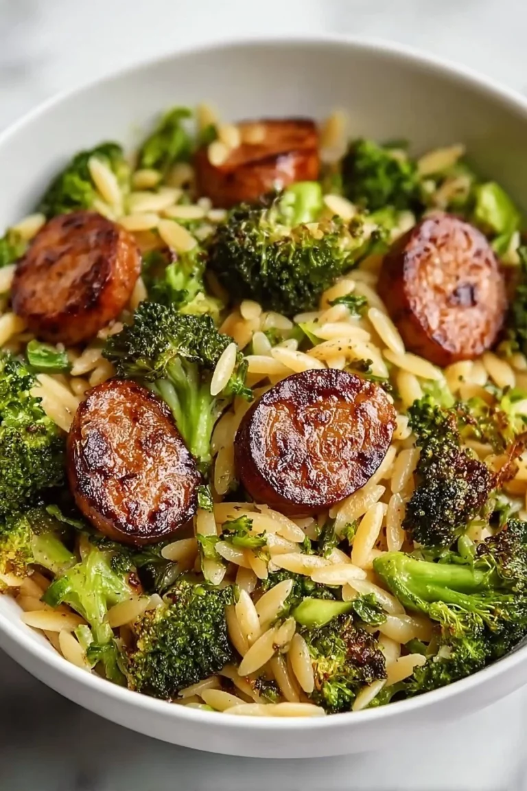 Chicken sausage broccoli orzo dish served in a bowl, showcasing vibrant colors.