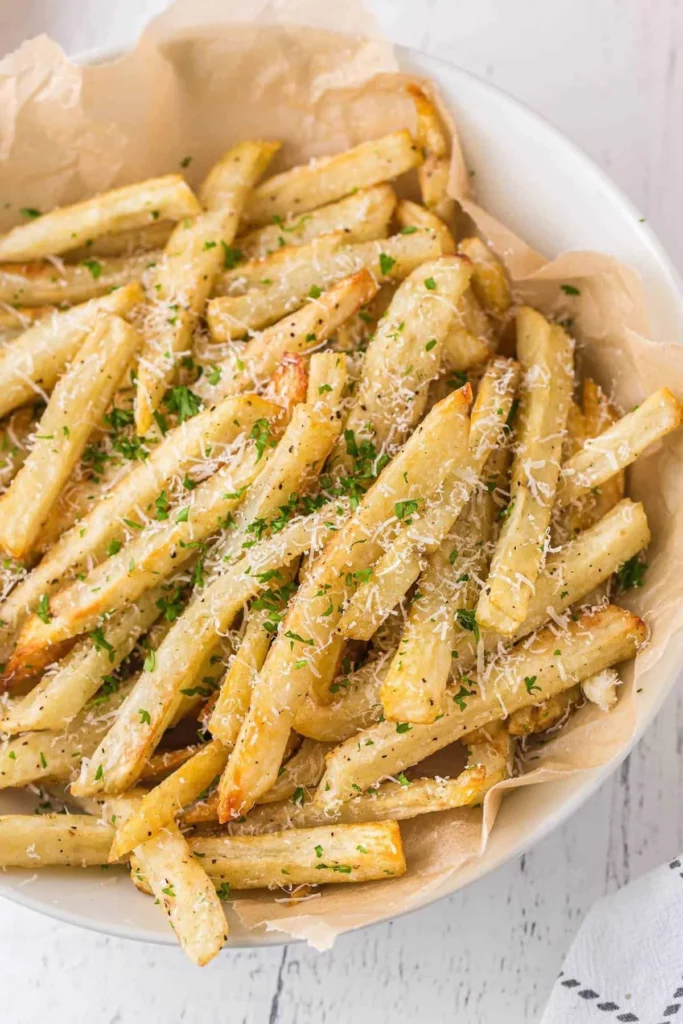 Crispy Garlic Parmesan Fries topped with herbs and cheese