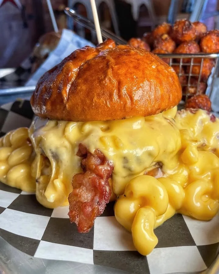 A deliciously messy burger overflowing with toppings and sauces.