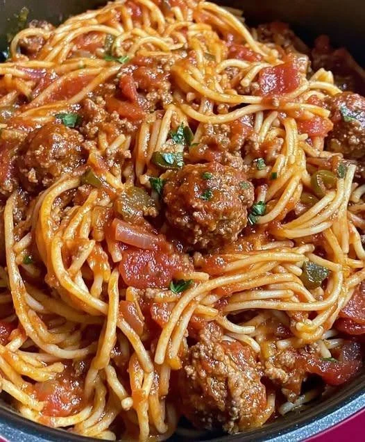 Plate of meatballs with rich tomato sauce garnished with herbs