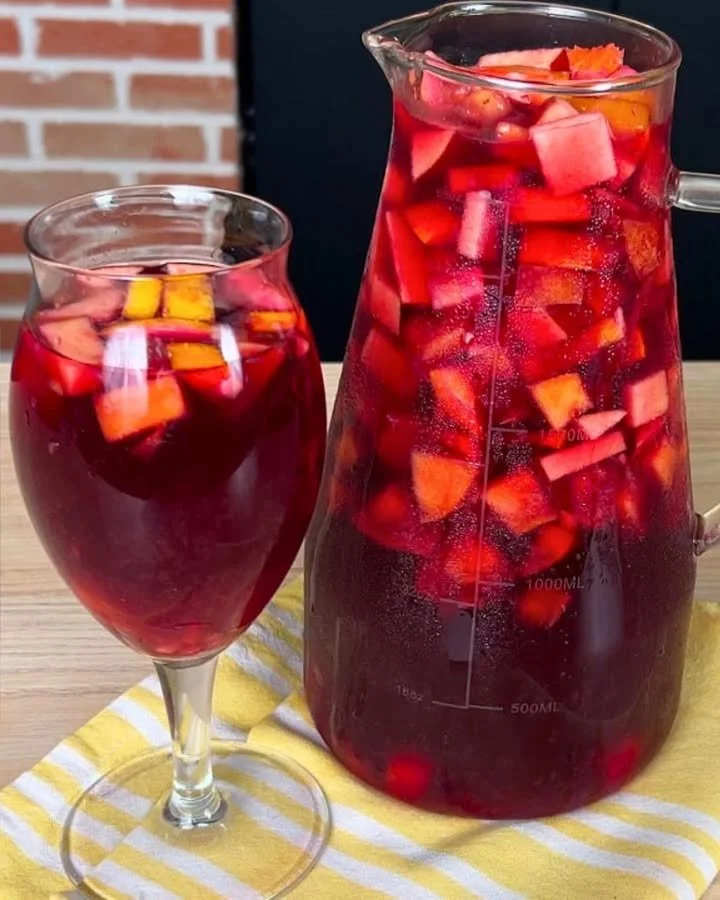 A refreshing glass of perfect sangria garnished with fruits and ice.