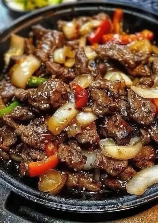 Sizzling Chinese pepper steak with onions served on a plate