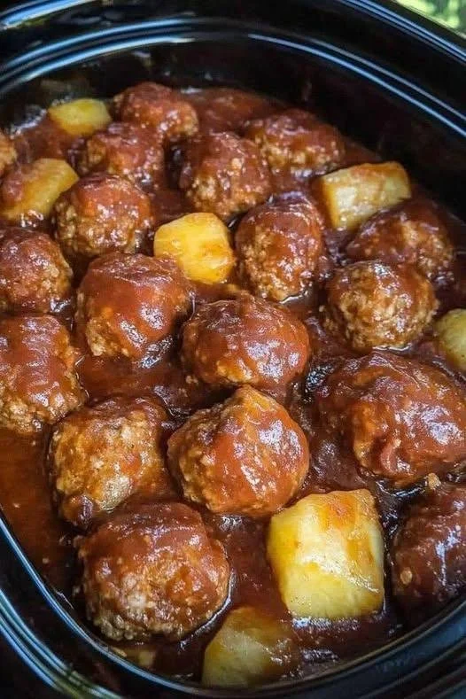 Plate of sweet and tangy meatballs garnished with herbs and sauce