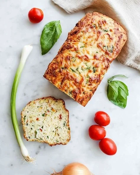 Delicious Vegetable Cheddar Zucchini Bread slice with melted cheese and fresh zucchini